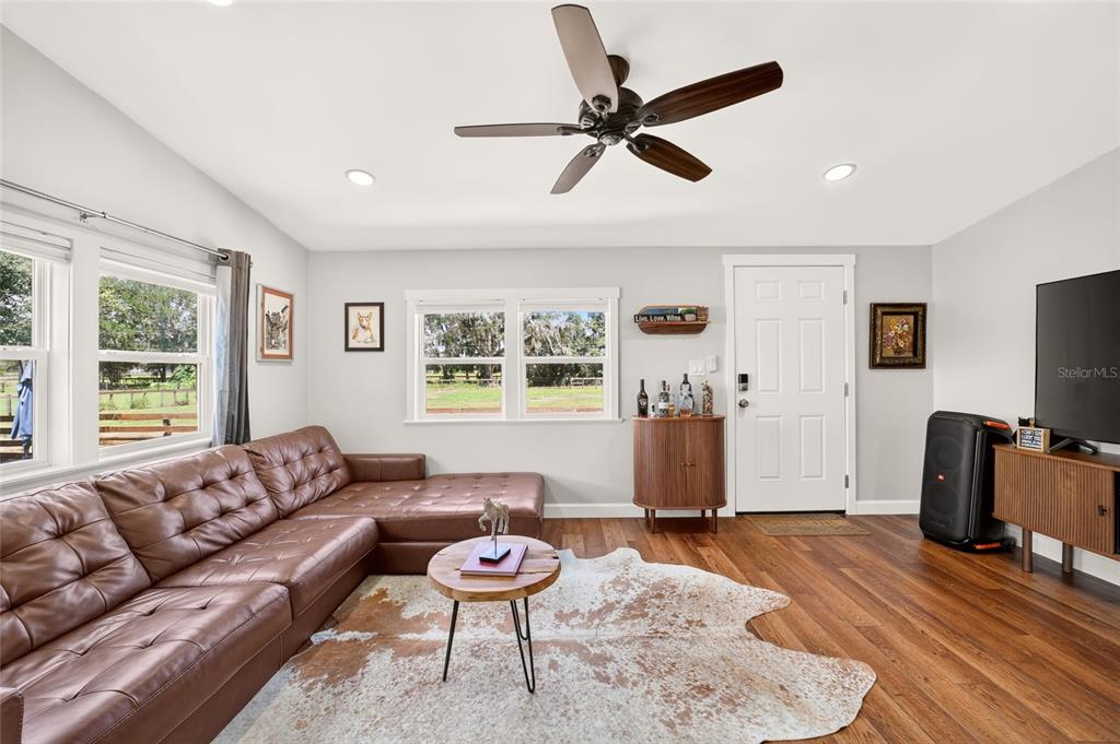 A living room features a brown leather sectional, a cowhide rug, and a ceiling fan — 8600 NE 41ST COURT, ANTHONY, FL