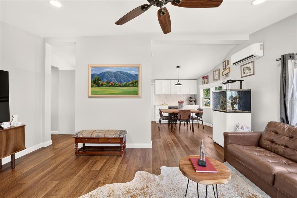 An open-concept living and dining area features wood flooring, a ceiling fan, and white cabinetry — 8600 NE 41ST COURT, ANTHONY, FL