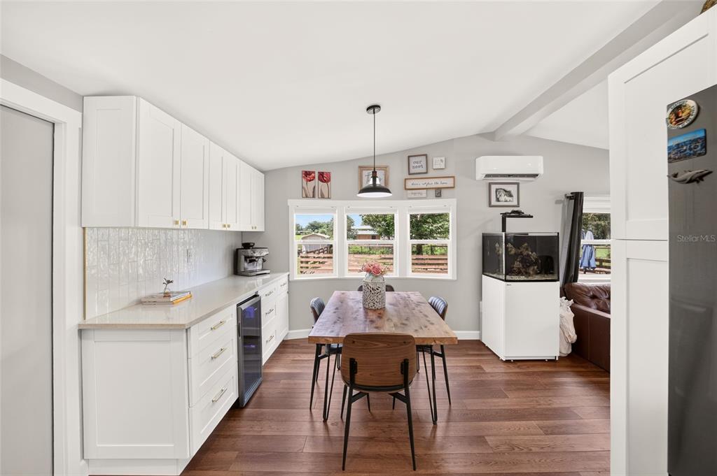A dining area features a wooden table, white cabinetry, and a large aquarium — 8600 NE 41ST COURT, ANTHONY, FL