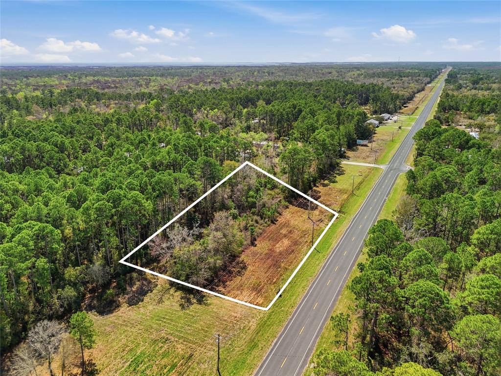 An aerial view shows a rectangular plot of land outlined in white beside a road — SW STATE ROAD 24, CEDAR KEY, FL