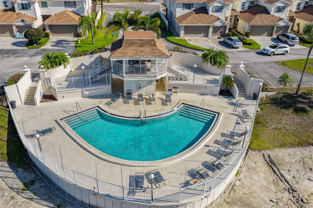 The exterior view shows two adjacent townhome units with white garage doors and arched entryways — 6400 46TH AVENUE N UNIT 71, KENNETH CITY, FL