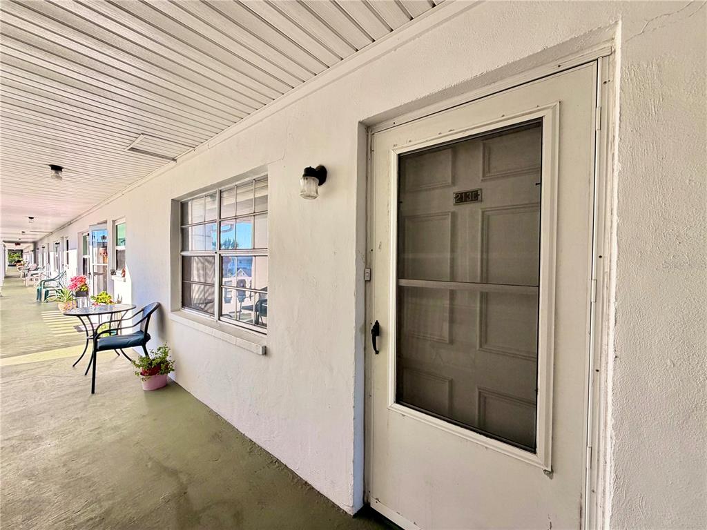 An aerial view shows a rectangular apartment complex with a central courtyard and swimming pool — 4746 AZALEA DRIVE UNIT 213, NEW PORT RICHEY, FL