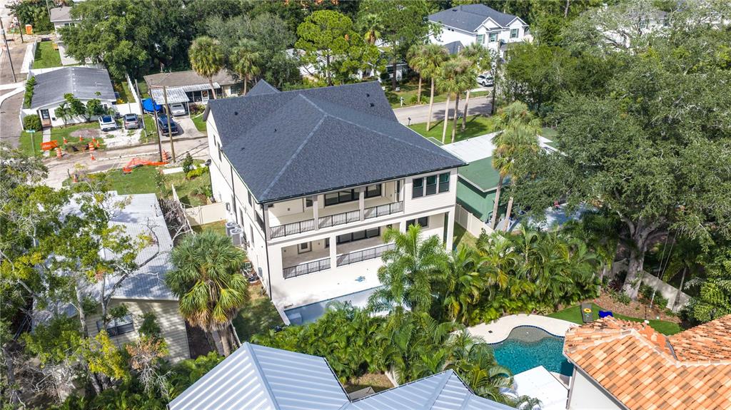 A two-story house under construction features green sheathing, concrete block walls, and a construction vehicle — 4316 W CORONA STREET, TAMPA, FL