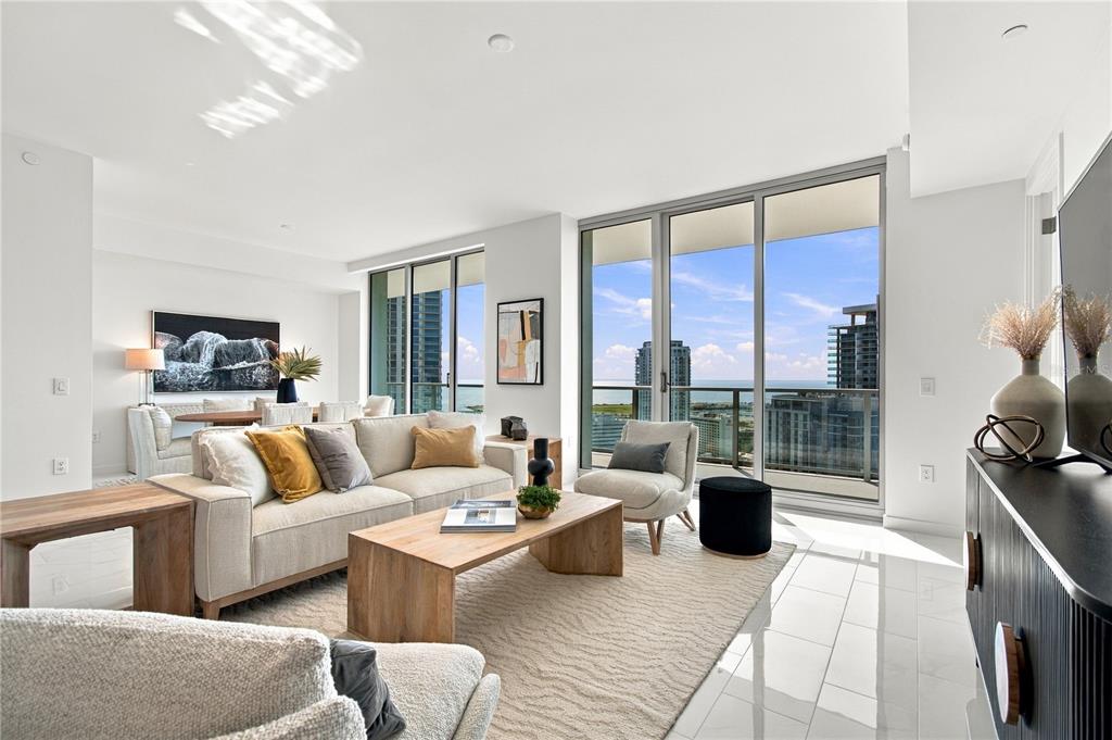 A furnished balcony with a city and water view overlooks a street with tall buildings — 400 CENTRAL AVENUE UNIT 2505, ST PETERSBURG, FL