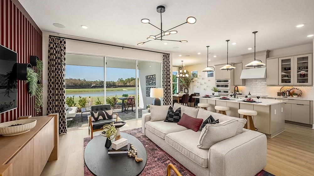 A modern kitchen features light-colored cabinetry, stainless steel appliances, a center island, and wood flooring — 17806 SEDONA STREET, WINTER GARDEN, FL