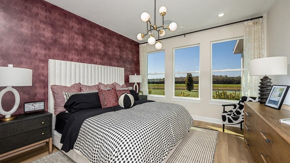 A living room features a dark red slat wall, a television, and large sliding glass doors — 17806 SEDONA STREET, WINTER GARDEN, FL