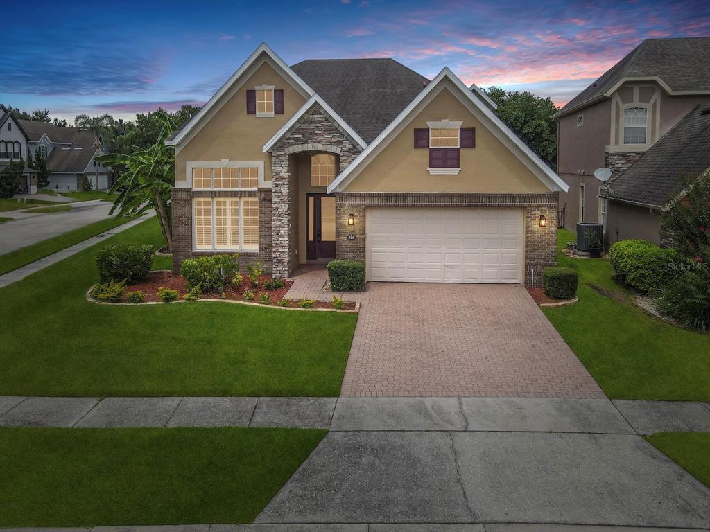 A two-story suburban house with a stone facade, a two-car garage, and a paved driveway — 930 SPRING OAK CIRCLE, ORLANDO, FL