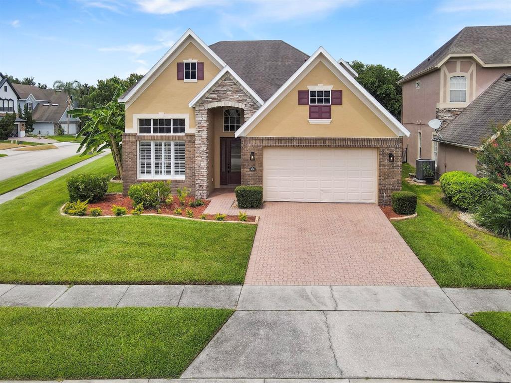 A two-story suburban house with a brick and stucco facade, garage, and paved driveway — 930 SPRING OAK CIRCLE, ORLANDO, FL