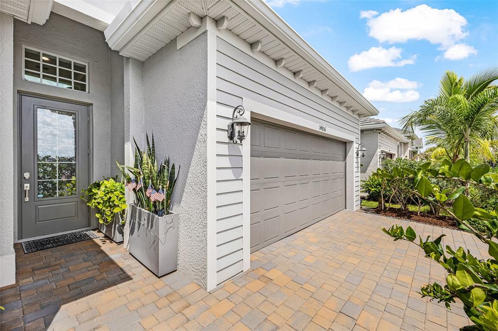 A gray house exterior features a paved driveway, a garage, and a front entryway — 14856 REDBUD LANE, PUNTA GORDA, FL