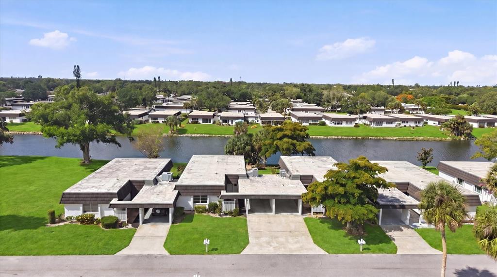 This open-concept living area features a home office, dining space, and views of water — 3960 LAKESIDE ROAD UNIT 156, SARASOTA, FL