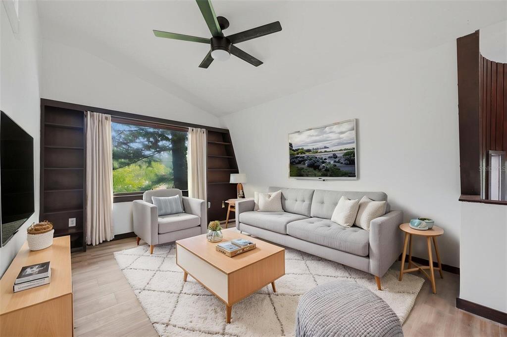 A living room with a grey sofa, armchair, coffee table, and built-in dark wood shelving — 15017 DAYTON DRIVE, HUDSON, FL