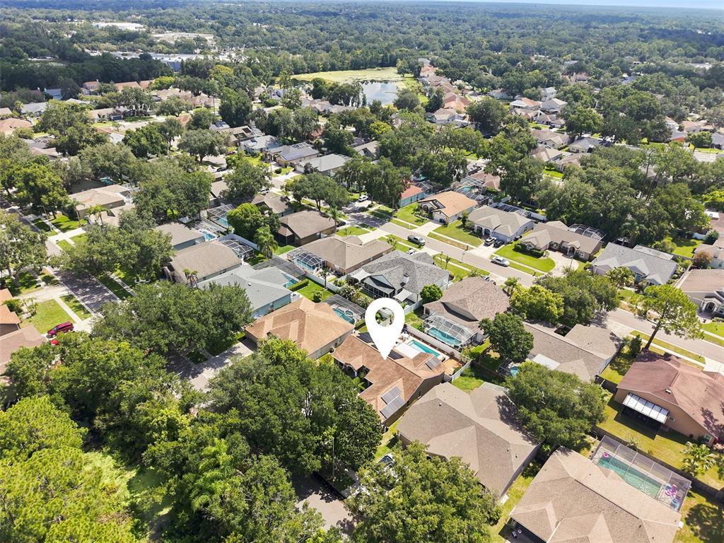 An aerial view of a house with solar panels, a swimming pool, and a patio — 3720 TREELINE DRIVE, VALRICO, FL