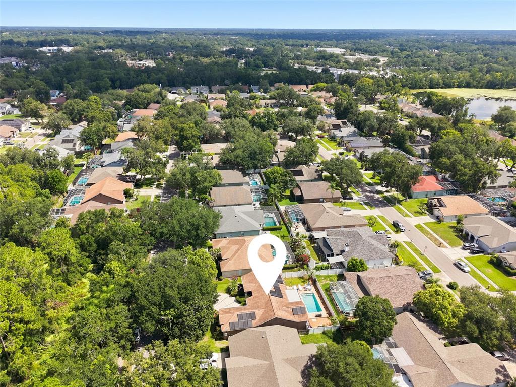 A kitchen features wood cabinets, granite countertops, stainless steel appliances, and a tiled floor — 3720 TREELINE DRIVE, VALRICO, FL