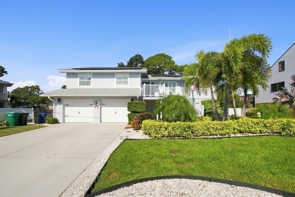 A two-story house with a two-car garage, a raised deck, and a landscaped front yard — 201 LAGOON DRIVE, PALM HARBOR, FL