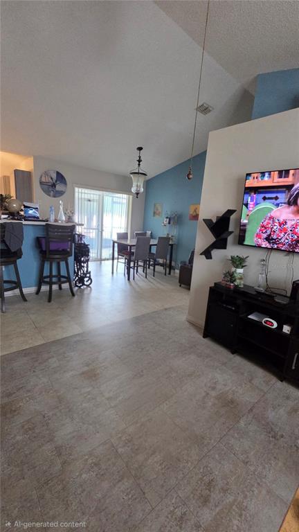 A living room and dining area feature tile flooring, blue accent walls, and vaulted ceilings — 36 BRADFORD COURT, KISSIMMEE, FL
