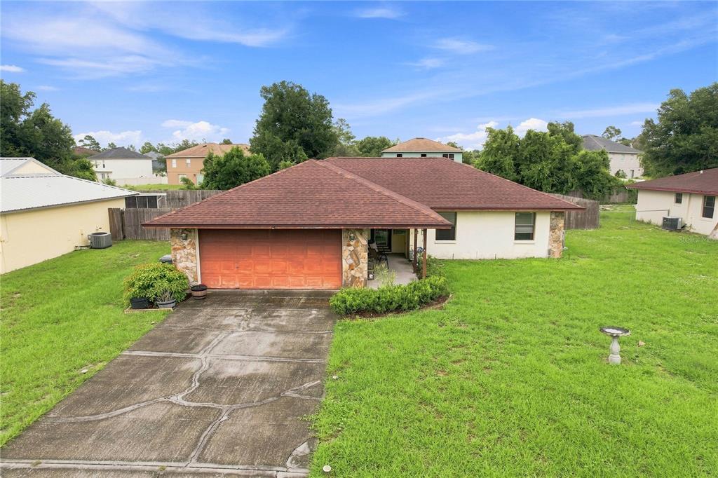 A single-story house with a brown roof, stone accents, and a two-car garage — 5055 CAMBRY LANE, LAKELAND, FL