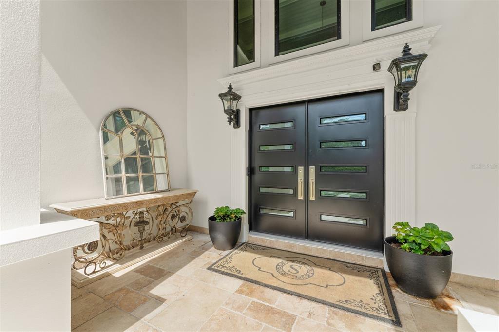 A front entryway features double black doors, a stone floor, and a decorative console table — 101 LEE STREET, WINDERMERE, FL