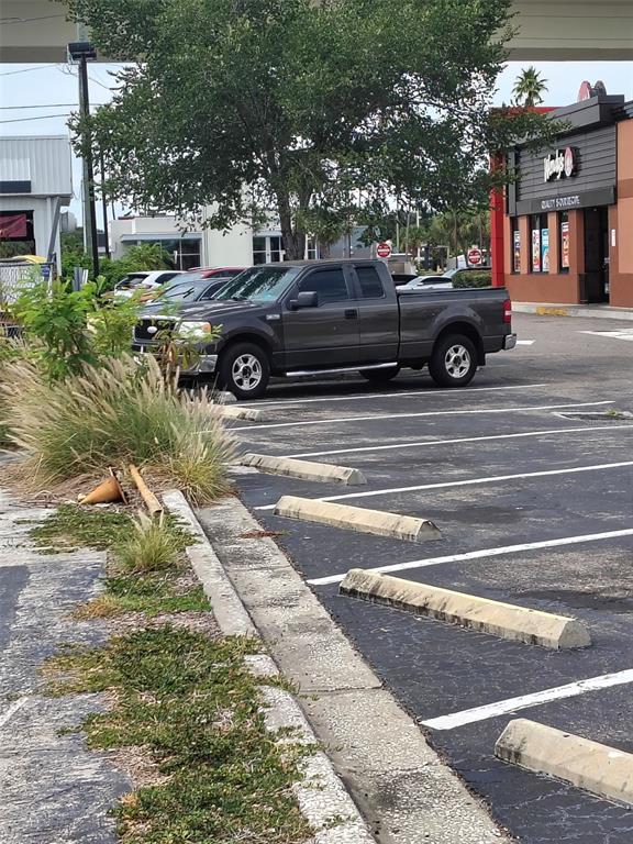 A dark gray pickup truck is parked in a paved parking lot near a restaurant — 4902 S MANHATTAN AVENUE, TAMPA, FL