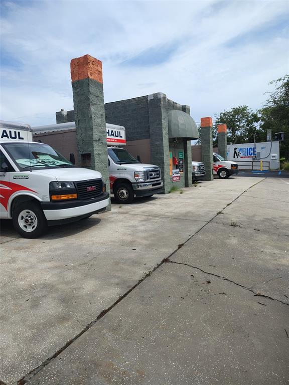A row of U-Haul trucks is parked in front of a commercial building with stone pillars — 4902 S MANHATTAN AVENUE, TAMPA, FL