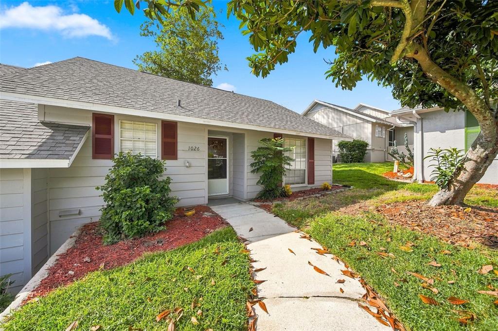 A single-story house with light gray siding, red shutters, and a concrete walkway — 1026 VILLA LANE UNIT 14, APOPKA, FL