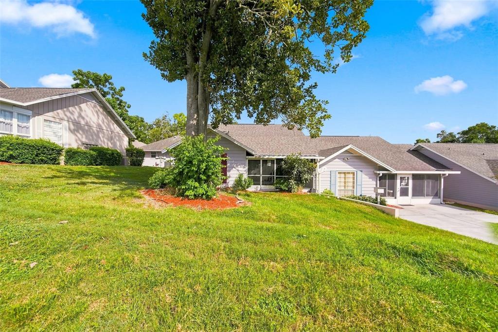 A single-story house with a large tree in the front yard and a concrete driveway — 1026 VILLA LANE UNIT 14, APOPKA, FL