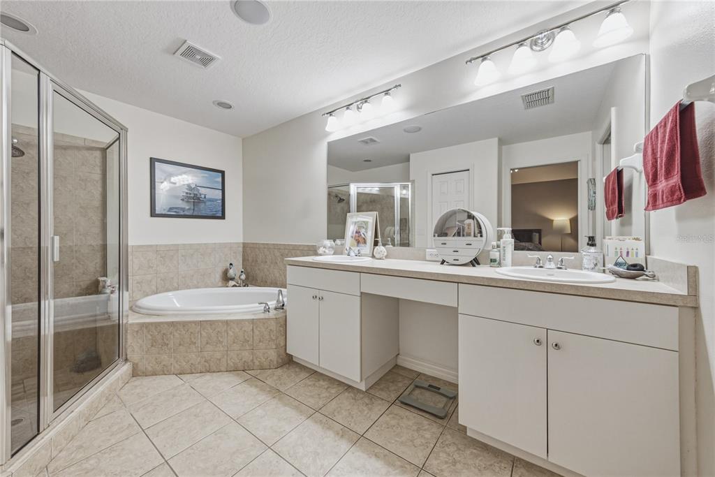 A bathroom features a glass shower, a corner soaking tub, and a double vanity — 2024 LARKSPUR COURT, TRINITY, FL