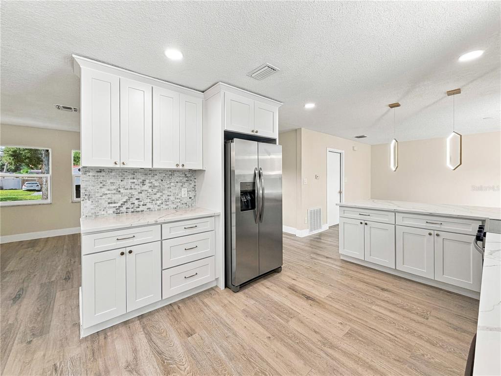 An interior view of an entryway featuring a white door with glass panels and lighting — 7015 CRESTLAKE DRIVE, ORLANDO, FL