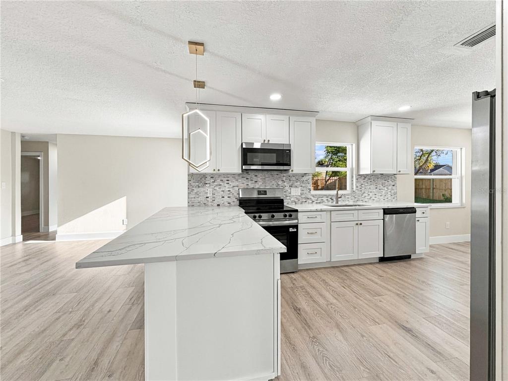 A white single-story house with a black garage door, black trim, and a manicured lawn — 7015 CRESTLAKE DRIVE, ORLANDO, FL