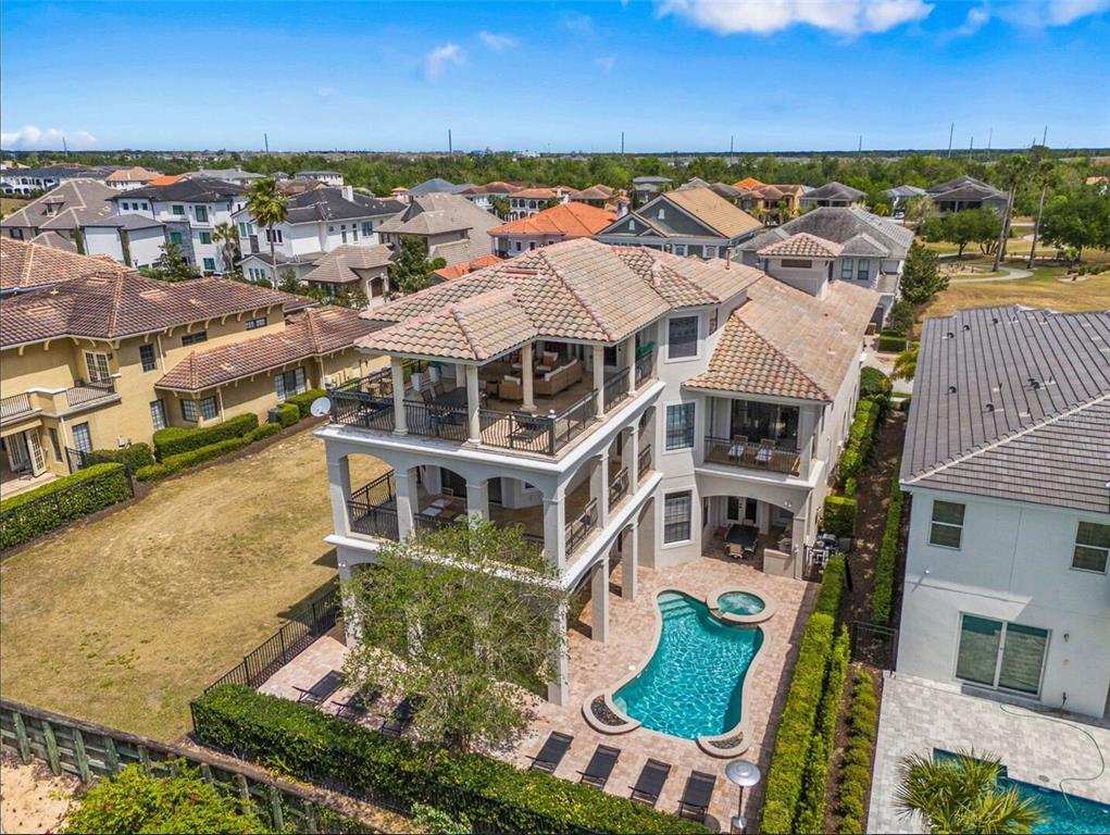 An aerial view of a three-story house with multiple balconies and a backyard swimming pool — 304 MUIRFIELD LOOP, REUNION, FL
