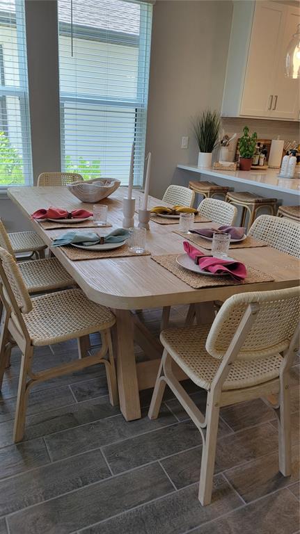 A dining room features a light wood table with cane chairs and tile flooring — 5419 SUMMIT GLEN, BRADENTON, FL