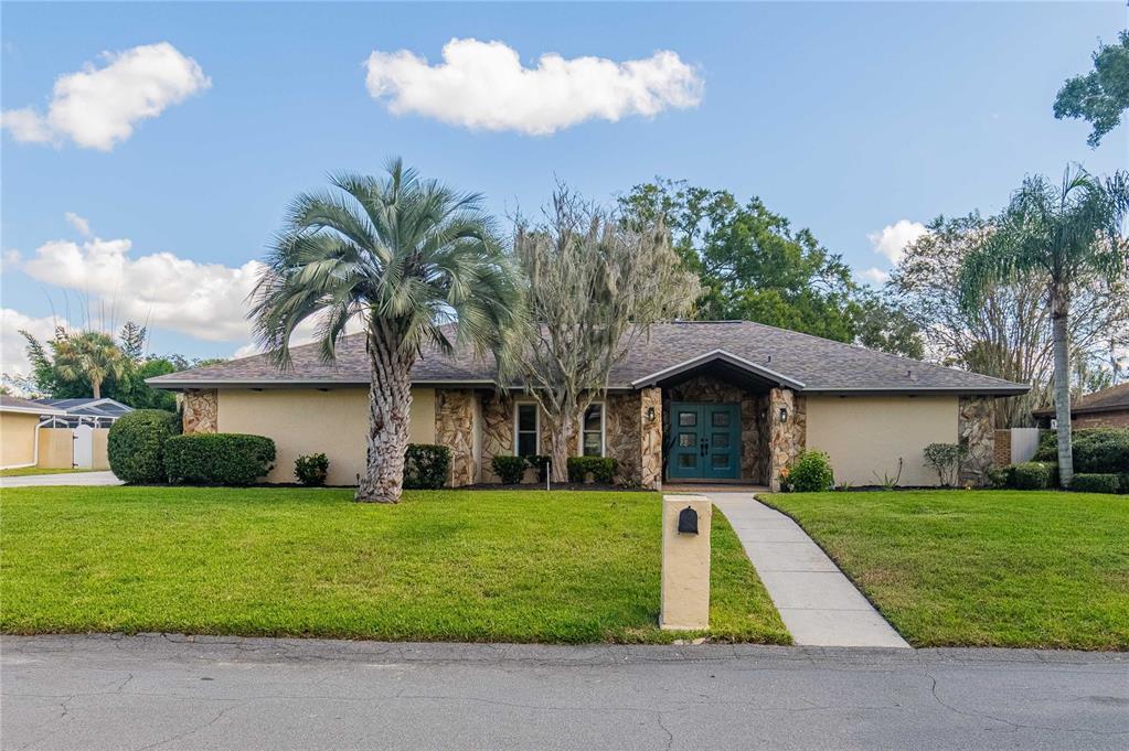A single-story house with a stone-accented entrance and a palm tree in the front yard — 4502 SUGARTREE DRIVE W, LAKELAND, FL