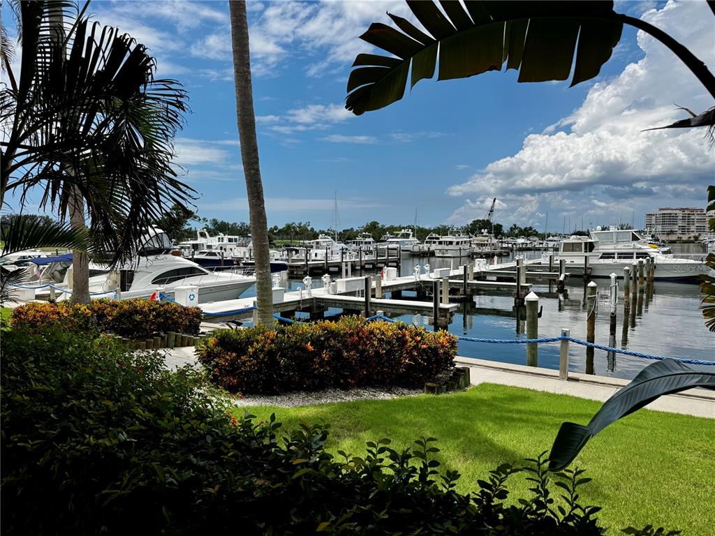 A view of a marina with multiple docked yachts and boats under a blue sky — 2600 HARBOURSIDE DRIVE UNIT C11, LONGBOAT KEY, FL