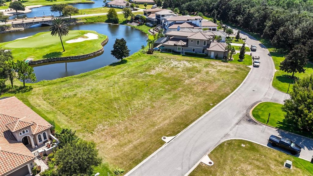 An aerial view shows a vacant residential lot situated between a lake and a road — 323 HIBISCUS WAY, PALM COAST, FL