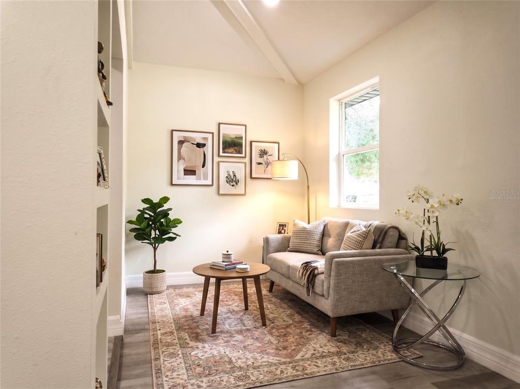 A living room features a grey sofa, a round coffee table, and a gallery wall — 919 W HIAWATHA STREET, TAMPA, FL