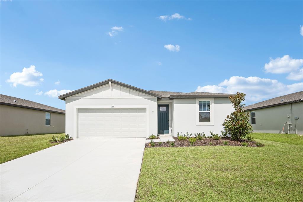 An entryway with light wood-look flooring, a white front door, and an open interior doorway — 1769 FOREST RUN LANE, AUBURNDALE, FL