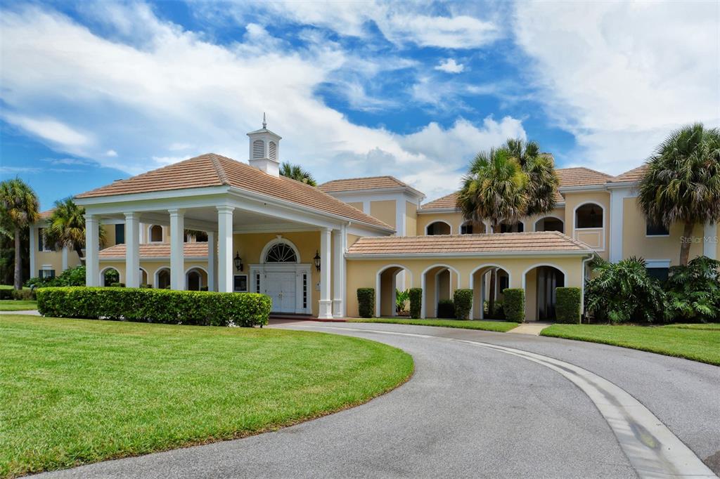A large, two-story building with a covered entrance, arched walkways, and a tile roof — 51 MACEWEN DRIVE UNIT 5, OSPREY, FL