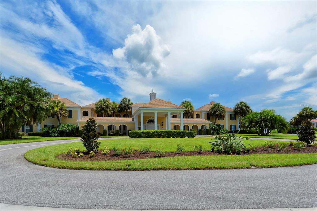 A large, two-story yellow building with a covered entrance and a circular driveway — 51 MACEWEN DRIVE UNIT 5, OSPREY, FL