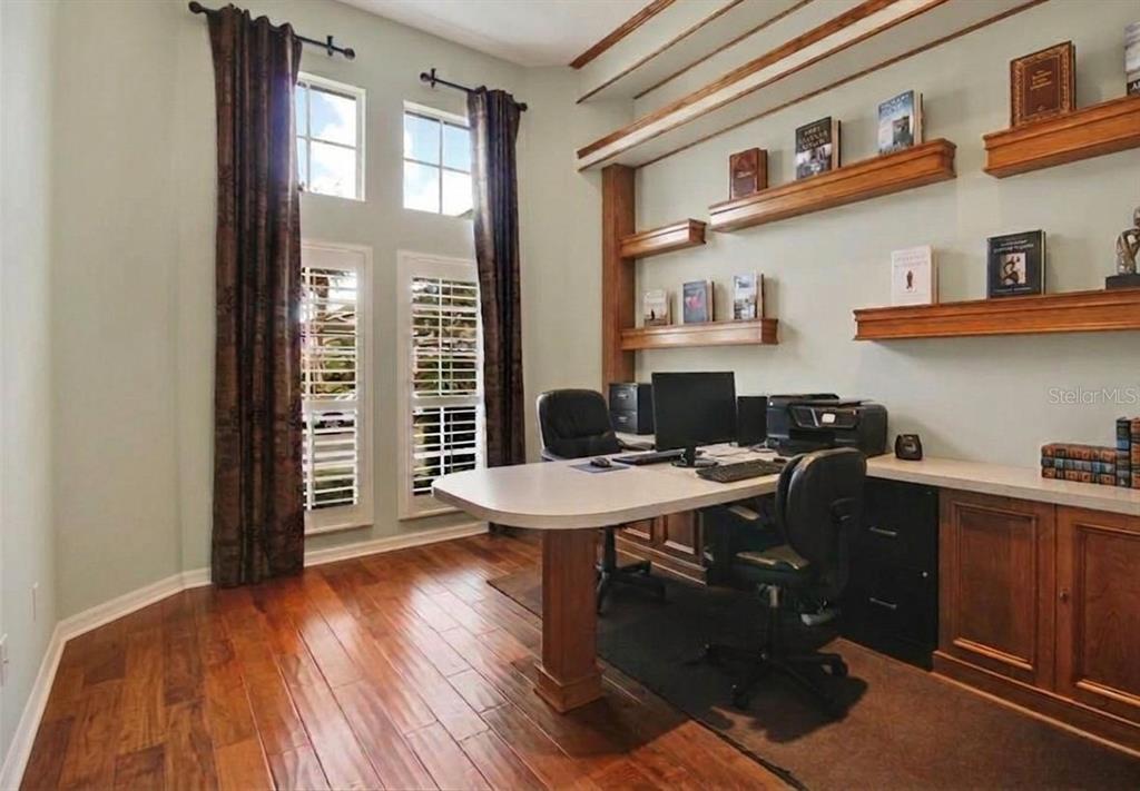 A bright entryway features a round pedestal table, a console table, and double glass doors — 8552 KESWICK POINTE DRIVE, ORLANDO, FL