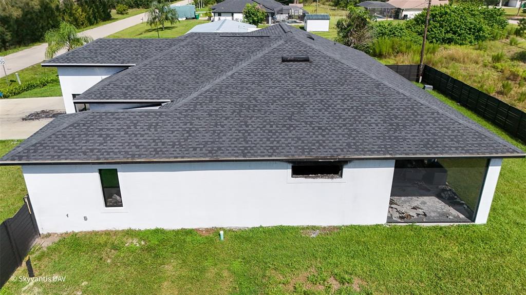 An aerial view shows the exterior of a white house with a dark shingled roof — 28005 PASADENA DRIVE, PUNTA GORDA, FL