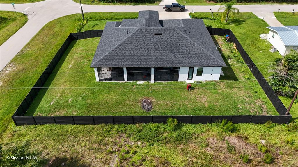An aerial view shows a house with a dark roof and a fenced-in backyard — 28005 PASADENA DRIVE, PUNTA GORDA, FL