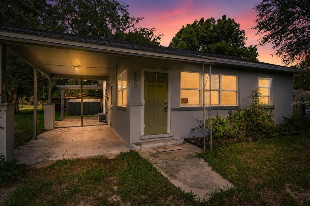 A single-story house with a light gray exterior, a green front door, and a carport — 730 WESTOVER PARKWAY, BARTOW, FL