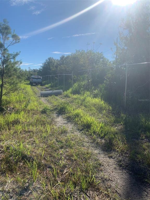 A dirt path leads toward a truck parked near a partially installed wire fence — 2701 METRO DRIVE, RUSKIN, FL