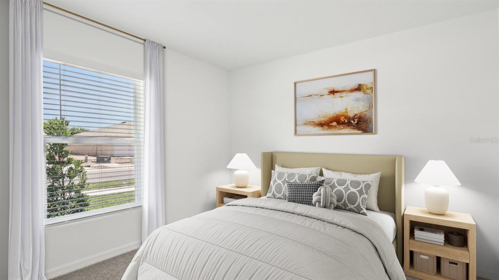 A bedroom features a bed with neutral bedding, two nightstands, lamps, and a window — 13379 CASTLE PEAK CIRCLE, DADE CITY, FL