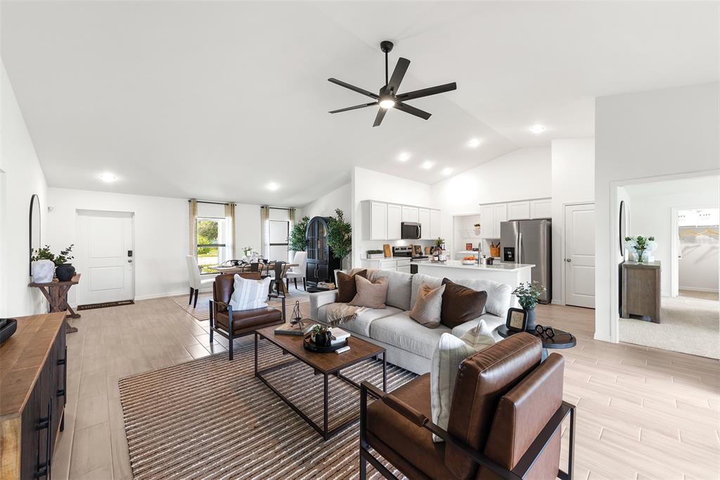 An open-concept living room and kitchen featuring light tile floors and a vaulted ceiling — 3445 W DITTANY DRIVE, CITRUS SPRINGS, FL