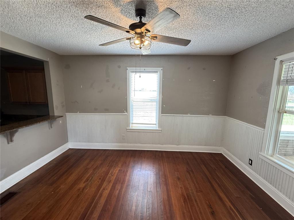 A dining room features hardwood floors, white wainscoting, a ceiling fan, and a center window — 1115 KELLER ROAD, FORT MEADE, FL