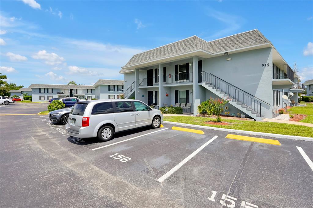 A two-story apartment building with a parking lot and a silver minivan in the foreground — 915 W OAK RIDGE ROAD UNIT B, ORLANDO, FL