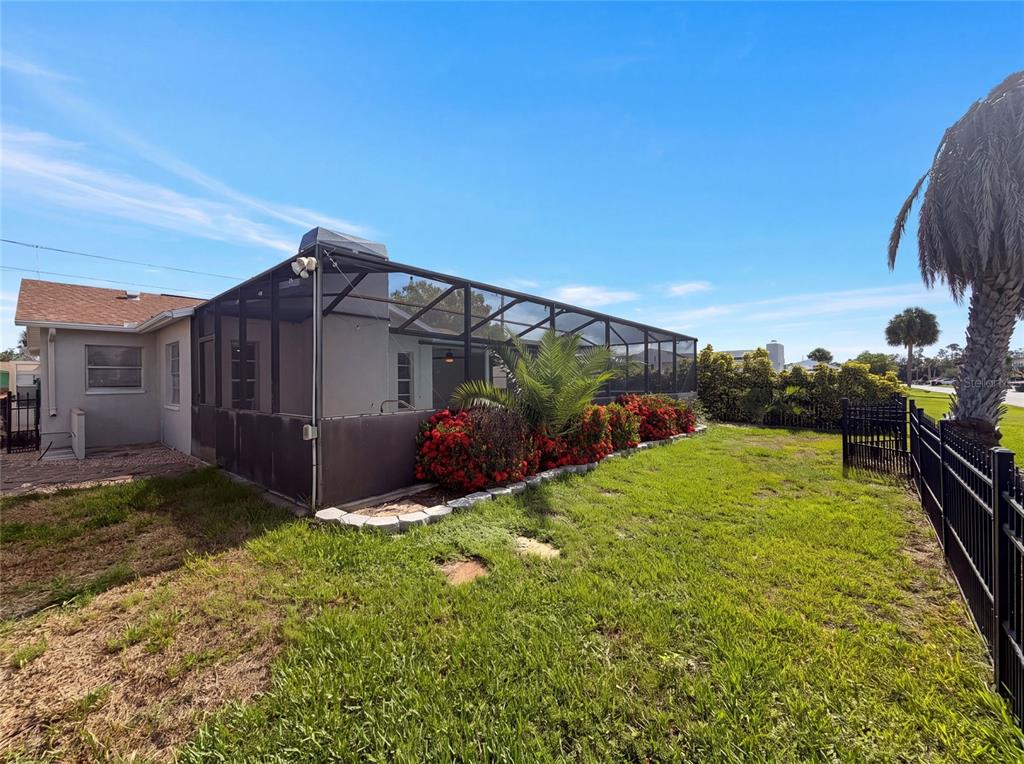 The exterior of a house features a screened-in patio area and a landscaped backyard — 7428 MAKO DRIVE, HUDSON, FL