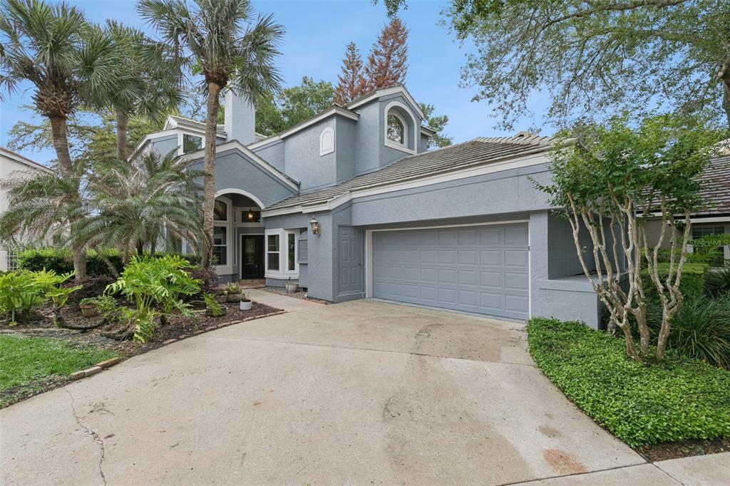 A two-story blue house with a concrete driveway, a two-car garage, and palm trees — 501 DEVON PLACE, LAKE MARY, FL