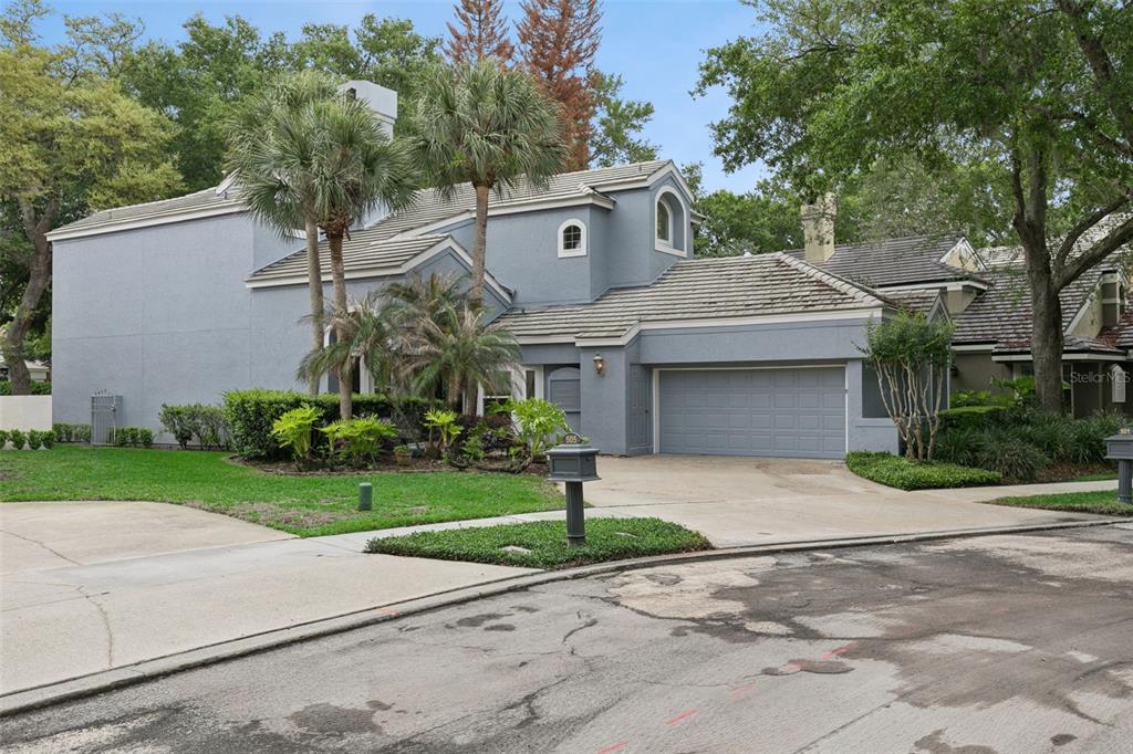 A two-story blue house with a gray tile roof, attached garage, and palm trees — 501 DEVON PLACE, LAKE MARY, FL