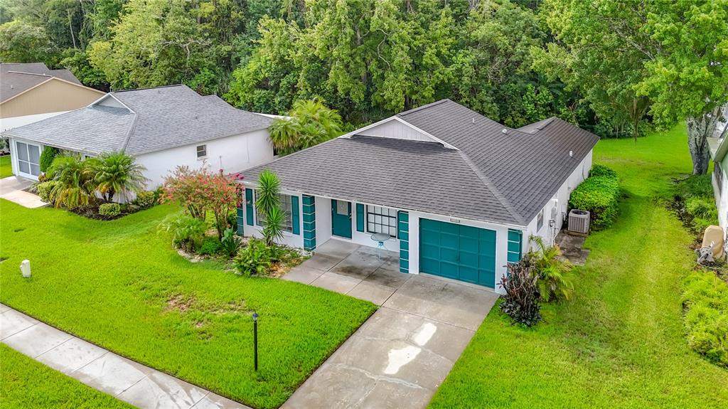 An aerial view of a single-story house with a dark roof and teal garage door — 11510 PAMPAS DRIVE, NEW PORT RICHEY, FL